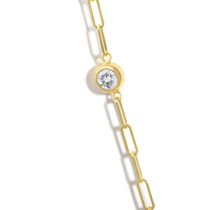 Close-up front view of a yellow metal necklace chain with a round white gemstone in a bezel setting.