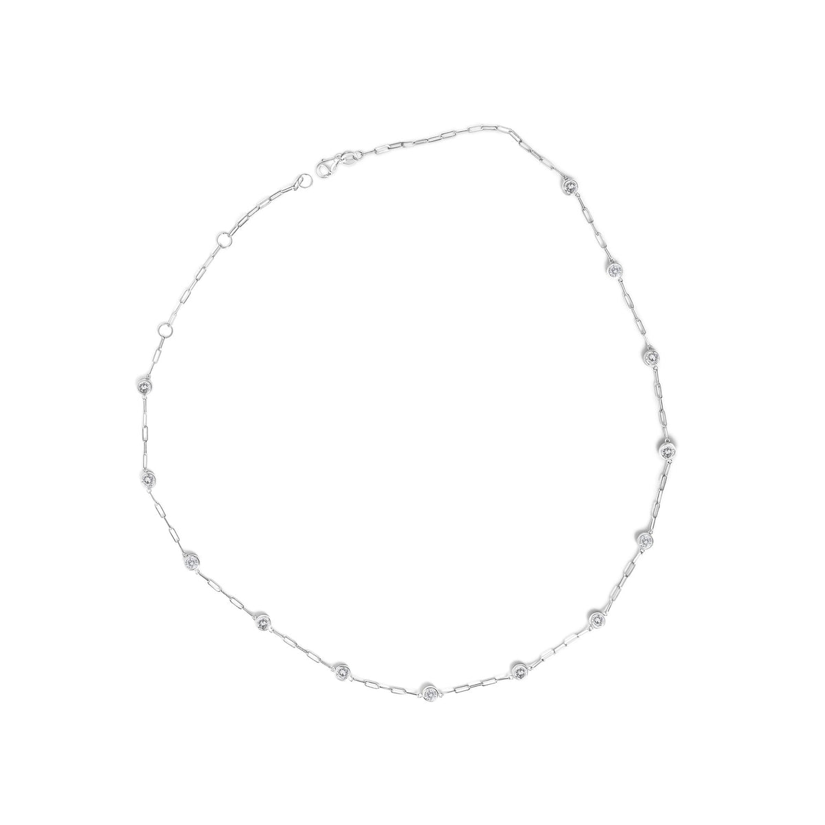 Close-up image of a white necklace laid flat, featuring a chain with evenly spaced round white gemstones in bezel settings, shot from above.