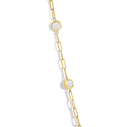 Close-up angled view of a yellow necklace chain with round white gemstones set in bezel settings along the chain.
