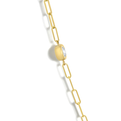 Close-up angled view of a yellow necklace with oblong chain links and a rounded square pendant featuring a round white gemstone in bezel setting.