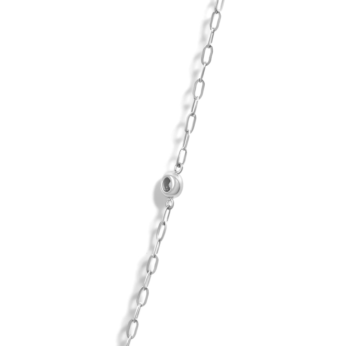 Close-up angled shot of a white necklace chain with a circular pendant featuring a bezel-set white gemstone inside.