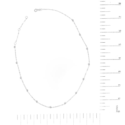 White metal necklace with evenly spaced round white gemstones in bezel settings, shown flat on a scale, top-down angle.