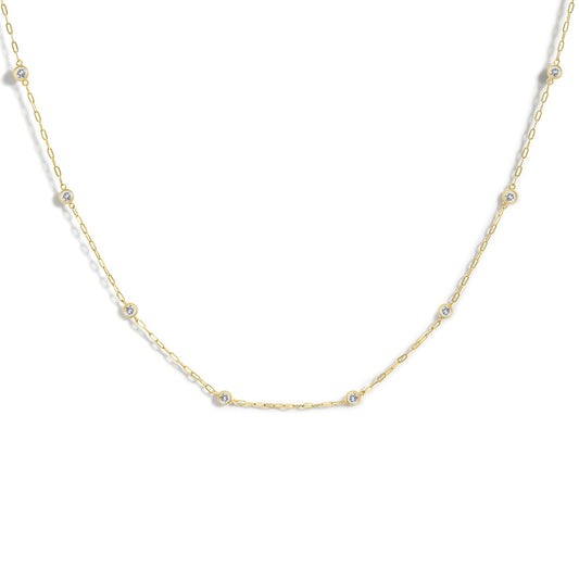 Close-up front angle of a yellow necklace featuring round white gemstones in bezel settings evenly spaced along a delicate chain, shown on a white background.
