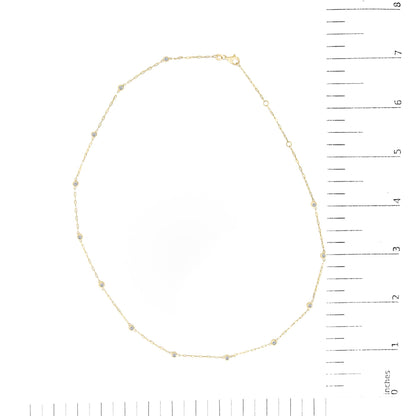 Yellow necklace with bezel-set round white gemstones spaced along a thin chain, shown flat on a scale, top-down view.