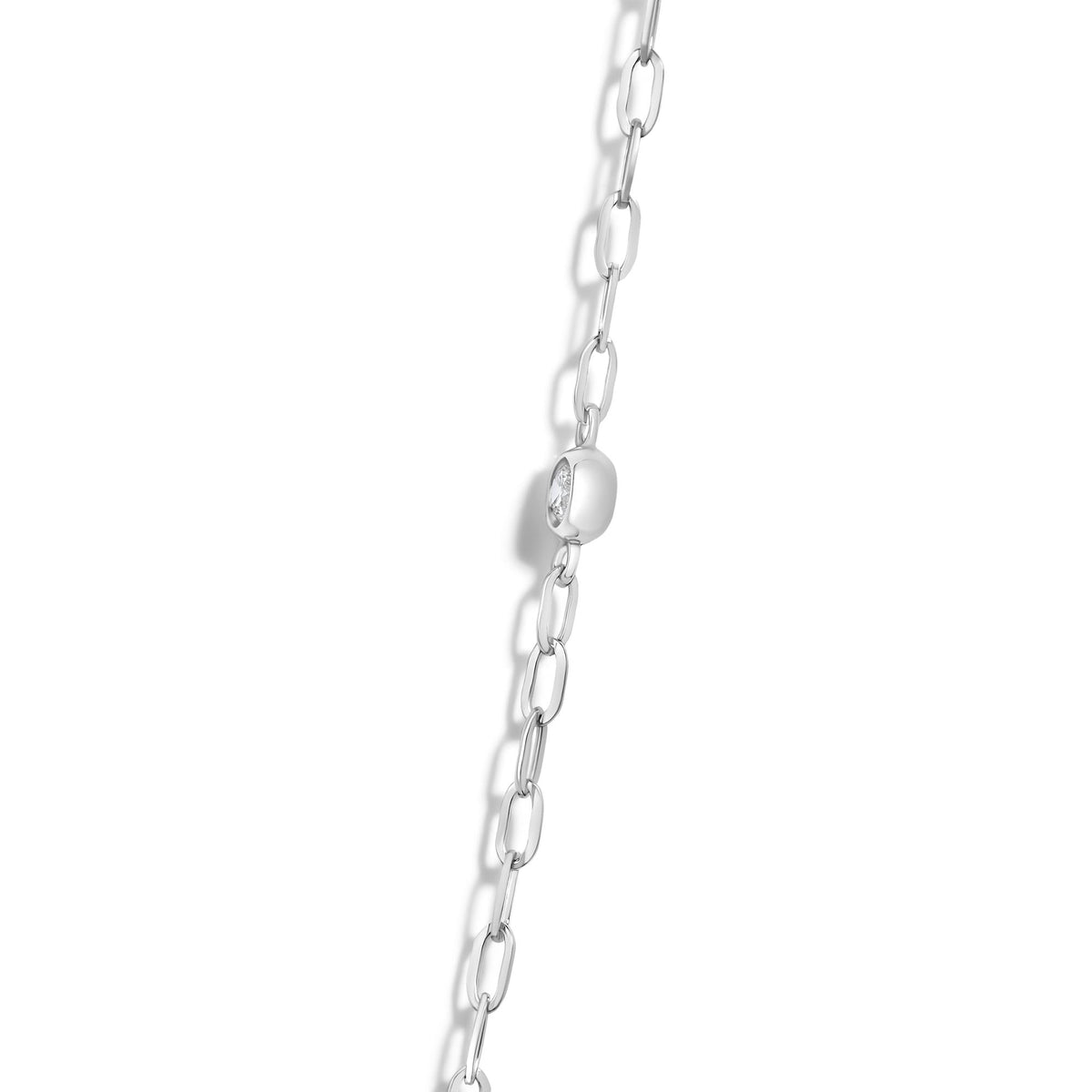 Close-up front angle of a white metal necklace chain with oval links, featuring round white gemstones in bezel settings integrated in some links.