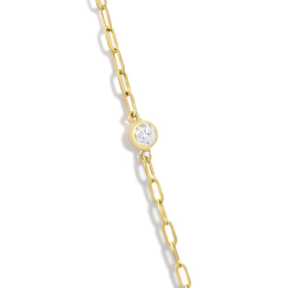 Close-up front view of a yellow necklace chain with a round white gemstone in a bezel setting.