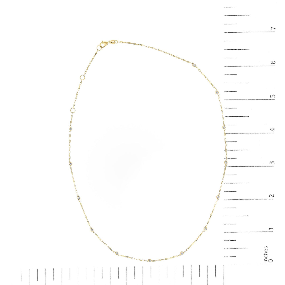 Yellow necklace with round white gemstones in bezel settings, shown flat on a scale, top-down view.