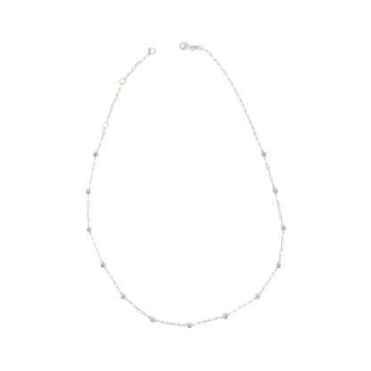 White necklace shown on a white background, viewed from the top with fine link chain and round white gemstones in bezel settings spaced evenly along the chain.