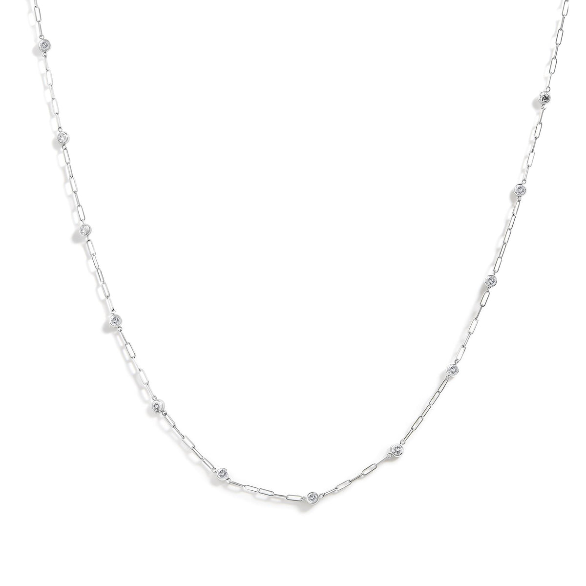Close-up front angle of a white metal necklace with round white gemstones in bezel settings spaced along a delicate chain.