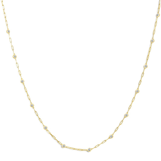 Close-up front angle of a yellow necklace chain with evenly spaced round white gemstones in bezel settings.