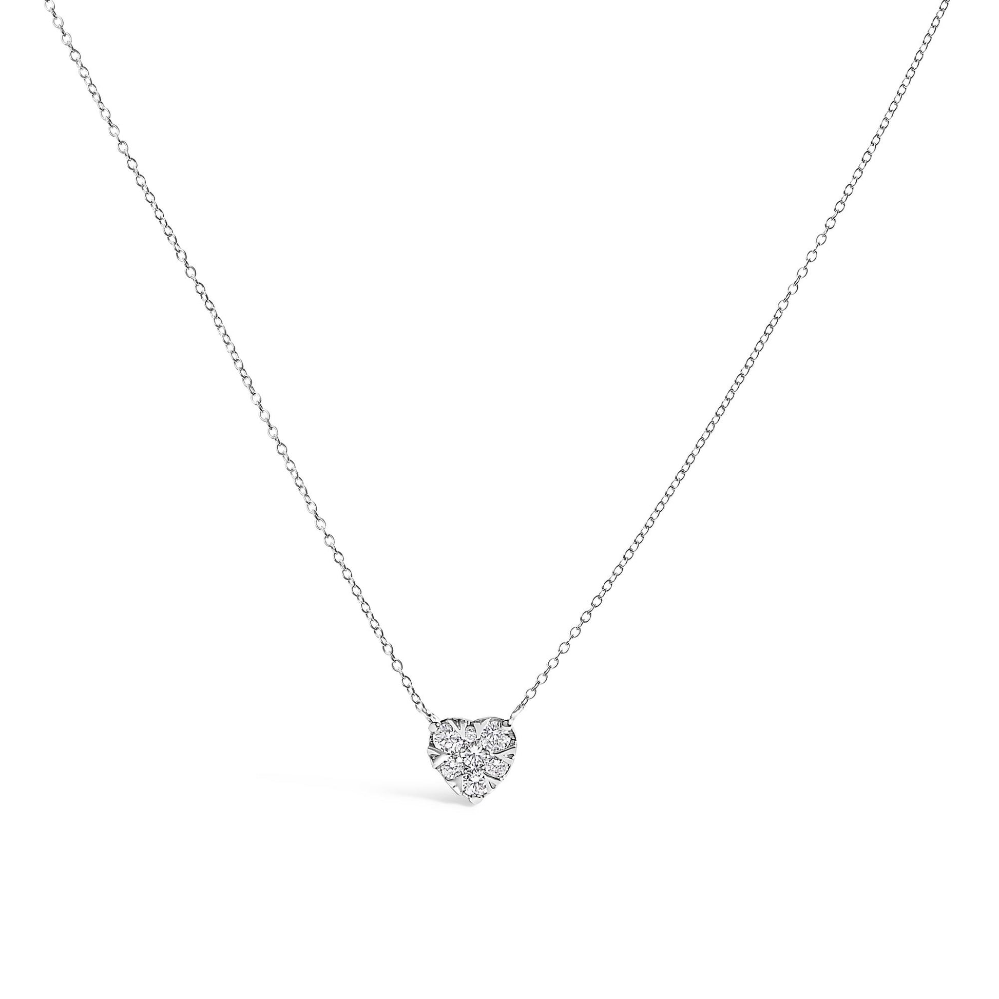 Close-up front view of a white necklace with a heart-shaped pendant featuring multiple round white gemstones in an invisible setting on a fine chain.