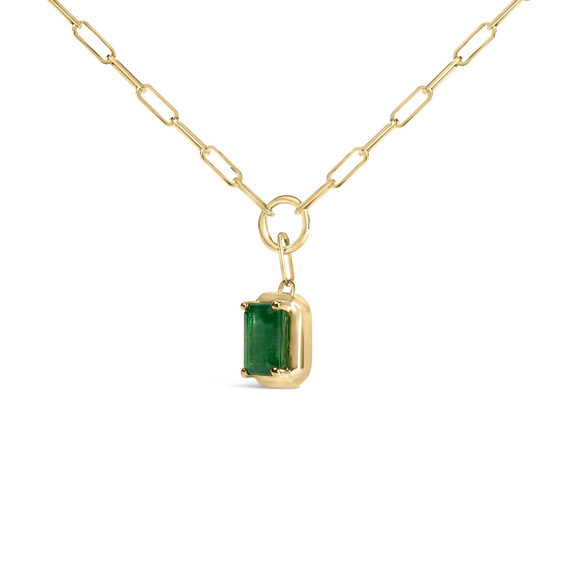 Close-up front angle of a yellow metal necklace with a rectangular green gemstone pendant in a bezel setting, shown on a white background.