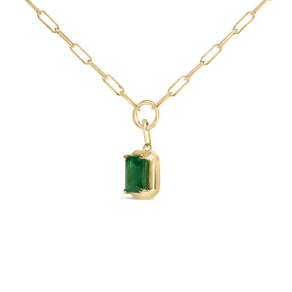 Close-up front angle of a yellow metal necklace with a rectangular green gemstone pendant in a bezel setting, shown on a white background.