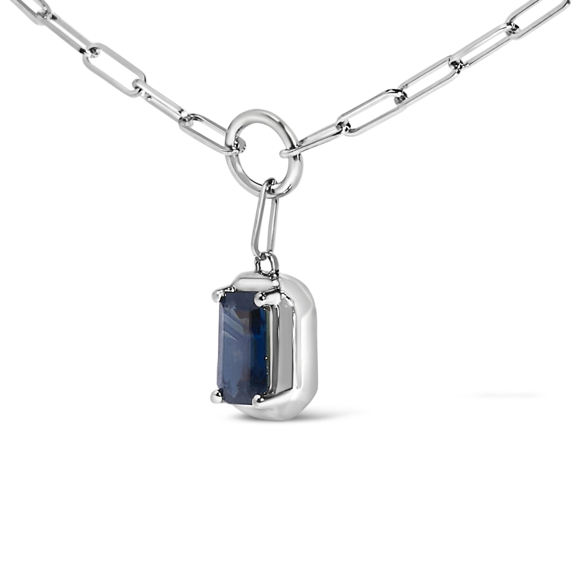 Close-up angled view of a white metal necklace with a rectangular blue gemstone in a bezel setting pendant hanging from a large round link.