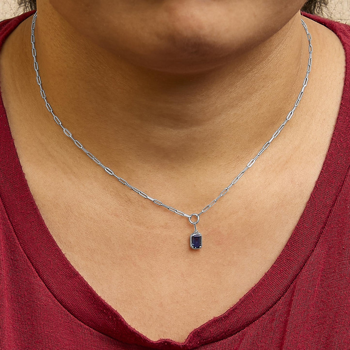 White metal necklace with rectangular blue gemstone pendant in bezel setting, shown worn on a model, front view.