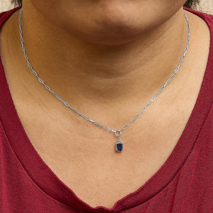 White metal necklace with rectangular blue gemstone pendant in bezel setting, shown worn on a model, front view.