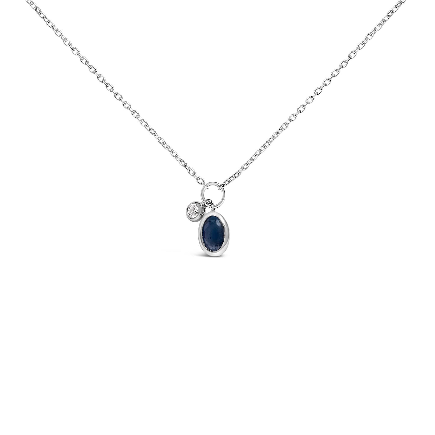 Front-facing shot of a white chain necklace with two small bezel-set pendants, one oval-shaped blue gemstone and one round white gemstone.