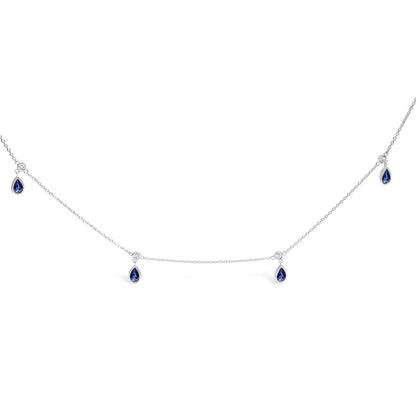 White necklace with a thin chain featuring alternating round white gemstones and pear-shaped blue gemstones in bezel settings, shown on a white background angle.