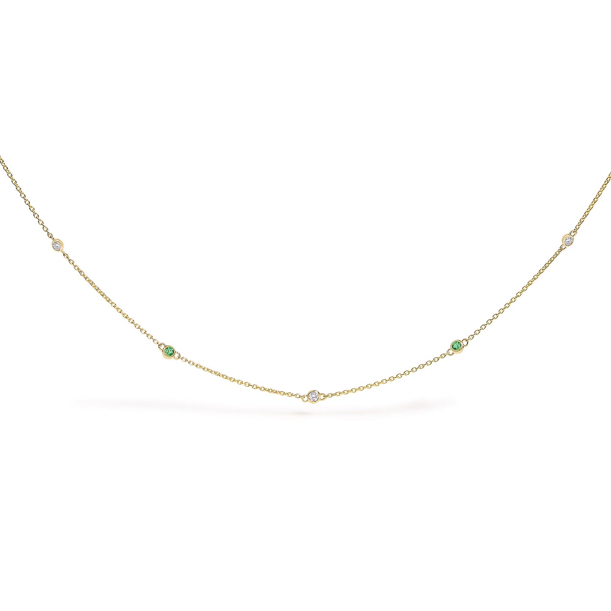 Yellow necklace with alternating round white and green gemstones in bezel settings, shown flat on a white background from a front angle.