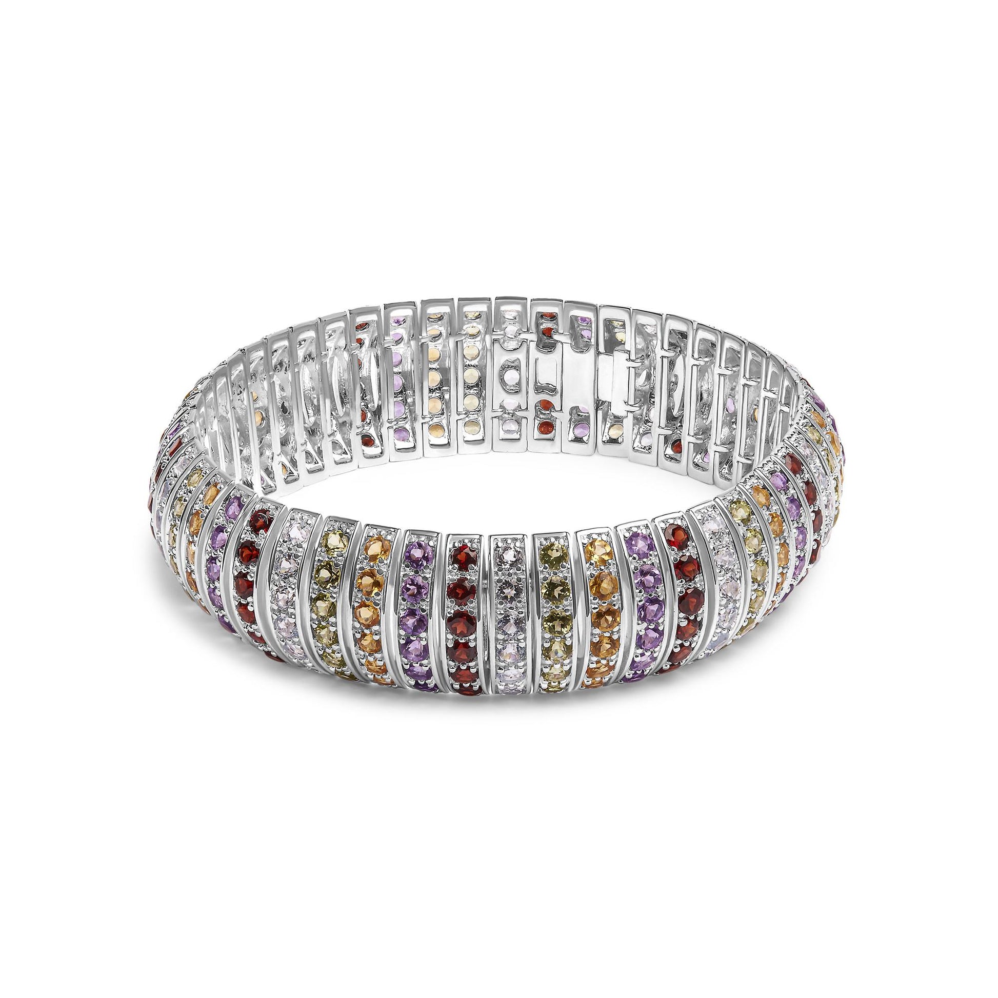 White metal bracelet set with rows of round purple, blue, lemon, yellow, and red gemstones in shared prong settings, shown at a slight angle.
