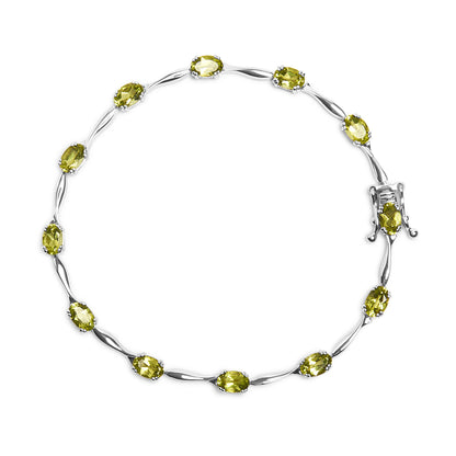 Top-down view of a white metal bracelet featuring oval green gemstones in four-prong settings, arranged in a continuous circle with a decorative clasp.