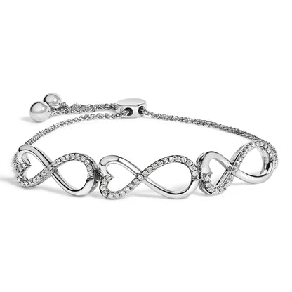 Close-up image of a white-colored bracelet with interlocking heart-shaped links, each outlined with small white gemstones in prong settings, shown from a slightly angled top view.