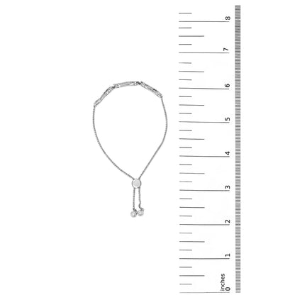 White bracelet with a central circular slider and adjustable ends, shown flat on a white background next to a scale, photographed from the top.