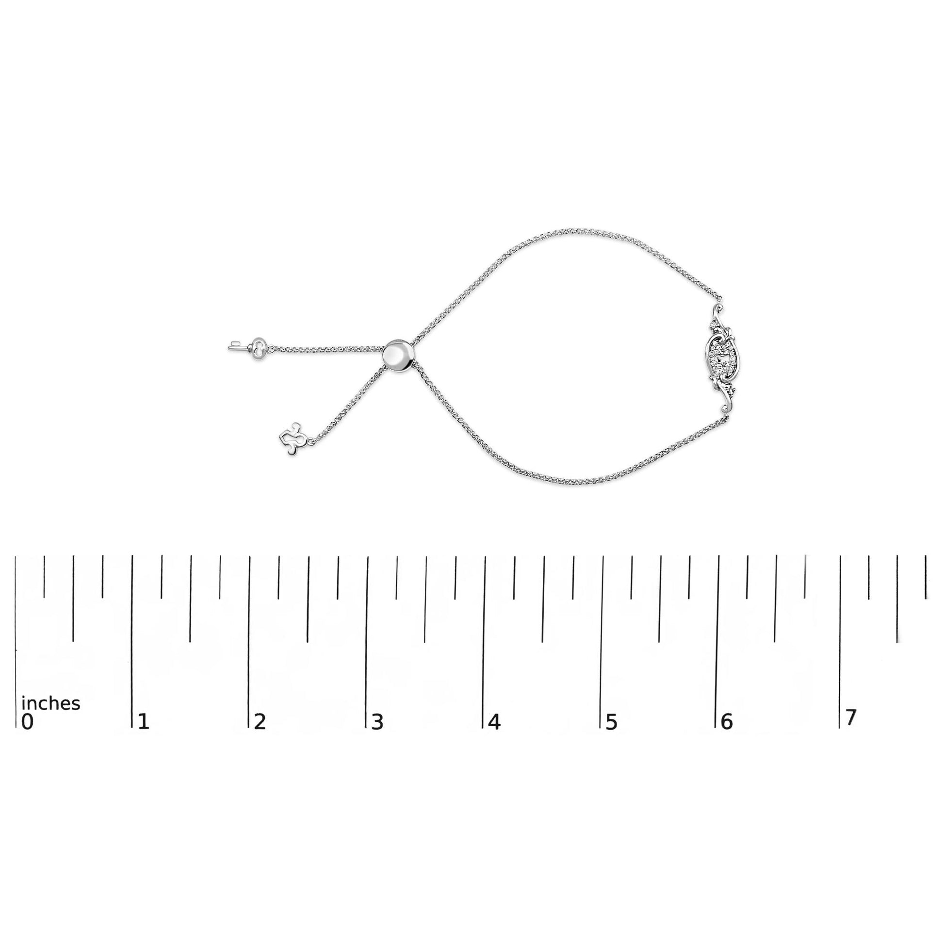 White metal bracelet with round white gemstones in shared prong setting, displayed flat on a ruler scale, top-down angle.