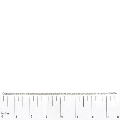 White metal bracelet with prong-set round white gemstones, displayed straight on a measuring scale, top-down view.
