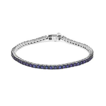 White metal bracelet with round blue gemstones in a shared prong setting, shown from a slightly elevated front angle.