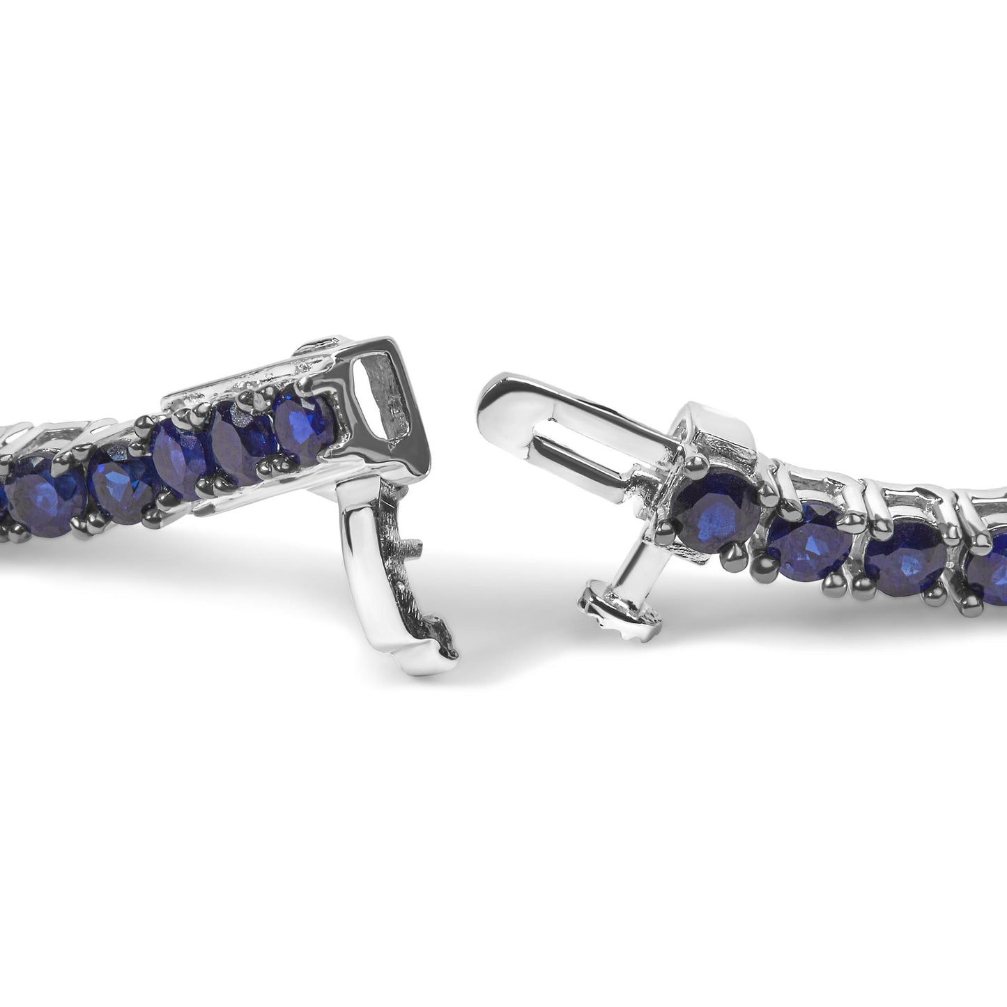 Close-up front angle of a white metal bracelet with round blue gemstones in a shared prong setting, showing the clasp detail.