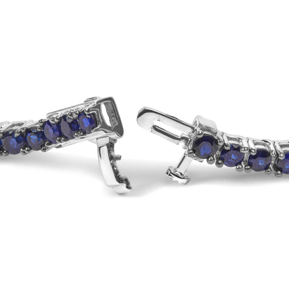 Close-up front angle of a white metal bracelet with round blue gemstones in a shared prong setting, showing the clasp detail.