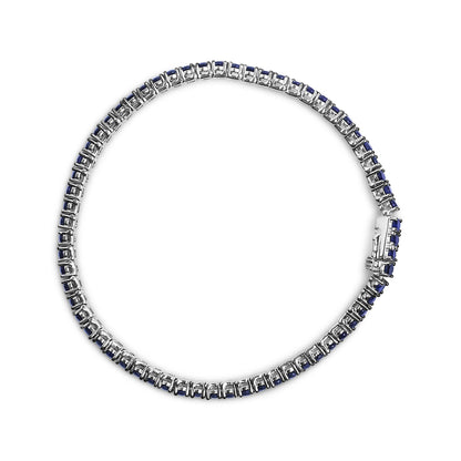 Top-down view of a white bracelet set with round blue gemstones in shared prong settings.