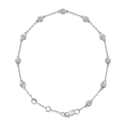 Top-down view of a white bracelet with round white gemstones in bezel settings evenly spaced along a delicate chain with a lobster clasp.