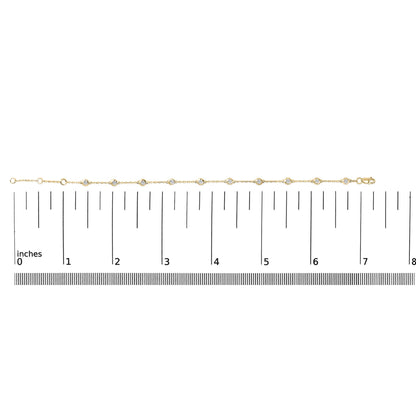 Yellow bracelet with round white gemstones in bezel settings, shown laid flat on a ruler for scale, front view.