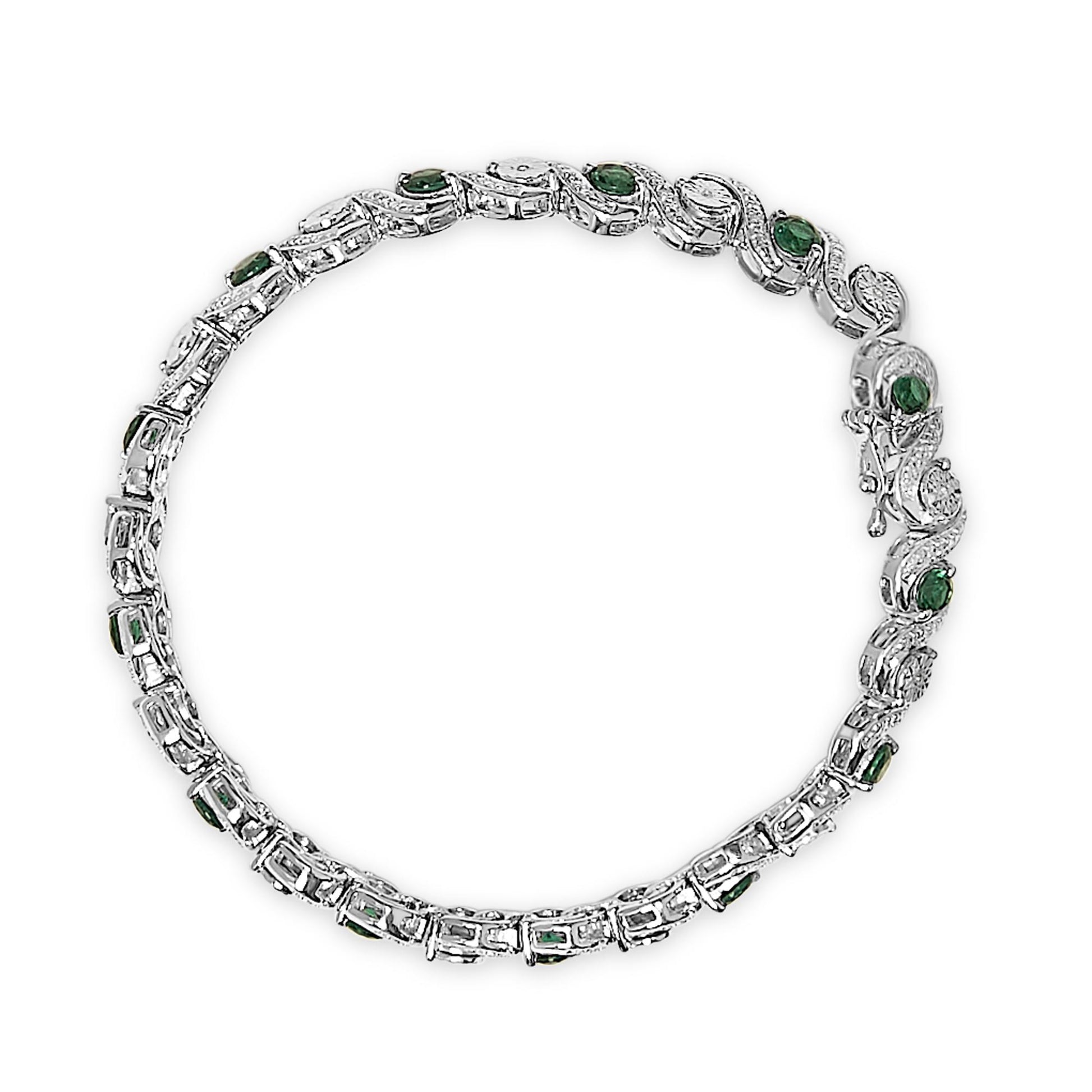 Top-down view of a white metal bracelet set with round white gemstones in a miracle setting and round green gemstones in a prong setting, arranged in a linked design.