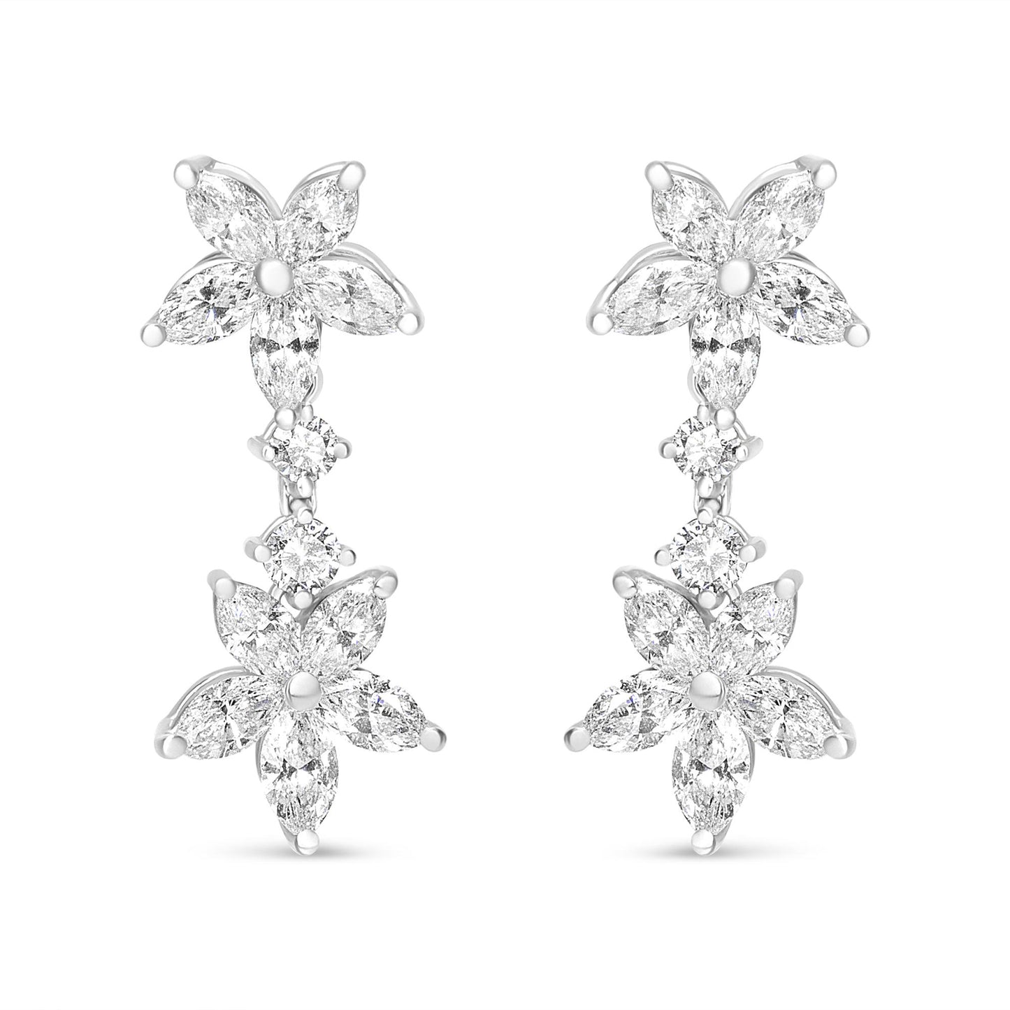 Front-facing shot of white metal earrings featuring two flower shapes composed of marquise-shaped white gemstones, connected by two round-shaped white gemstones in prong settings.