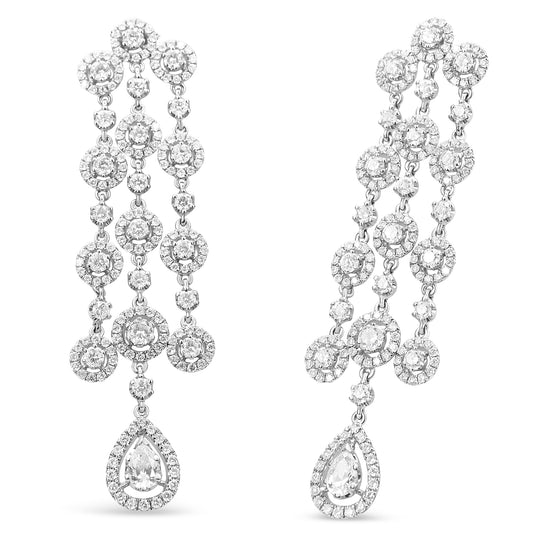 Front angle view of a pair of white metal earrings featuring multiple round gemstones in prong and pave settings forming a cascading design, ending with a pear-shaped gemstone surrounded by smaller round gemstones.