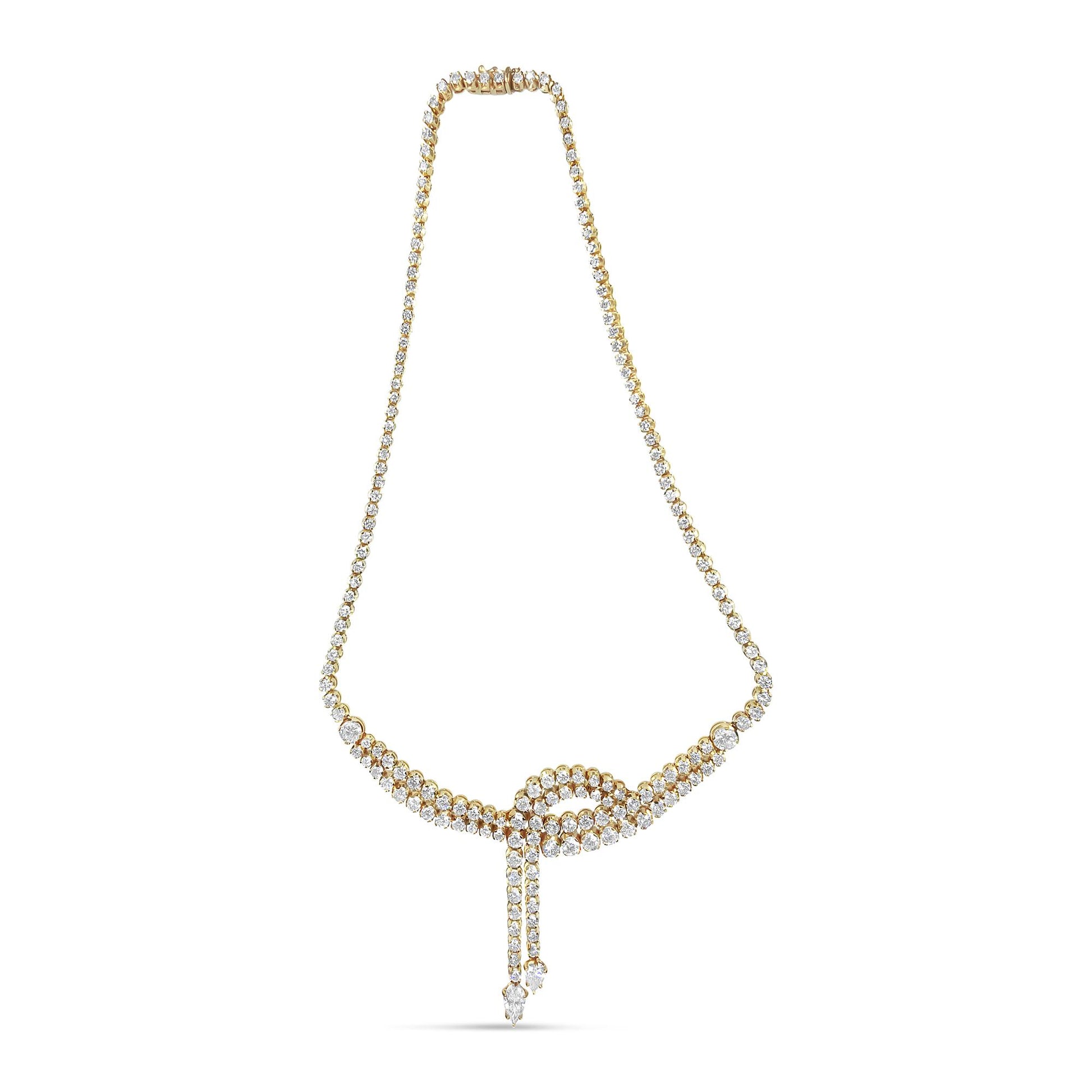 Front view of a yellow metal necklace with a knot design featuring round and pear-shaped white gemstones in prong settings.