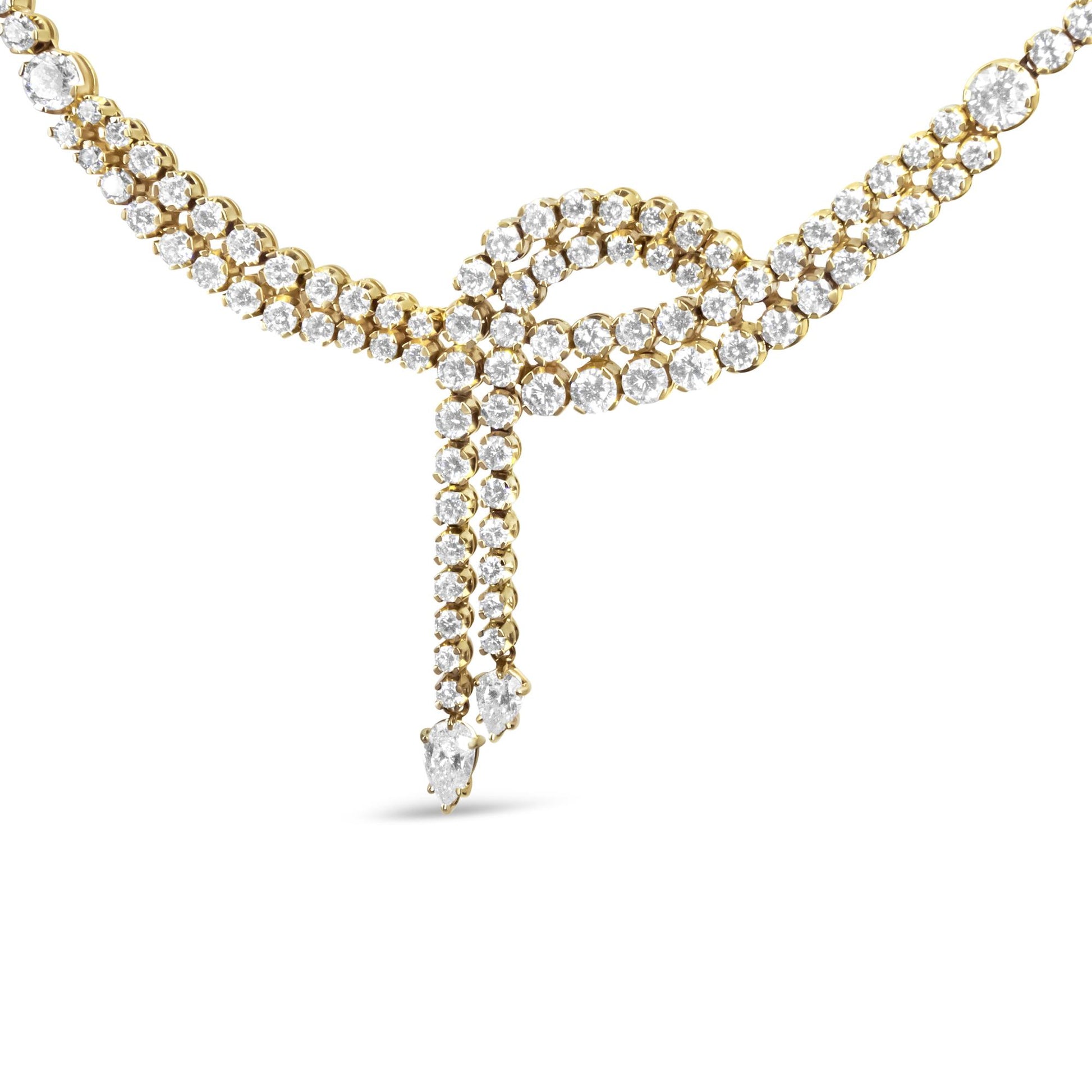 Close-up front view of a yellow necklace featuring intertwined strands adorned with round white gemstones and two dangling ends each with a pear-shaped white gemstone at the tip.