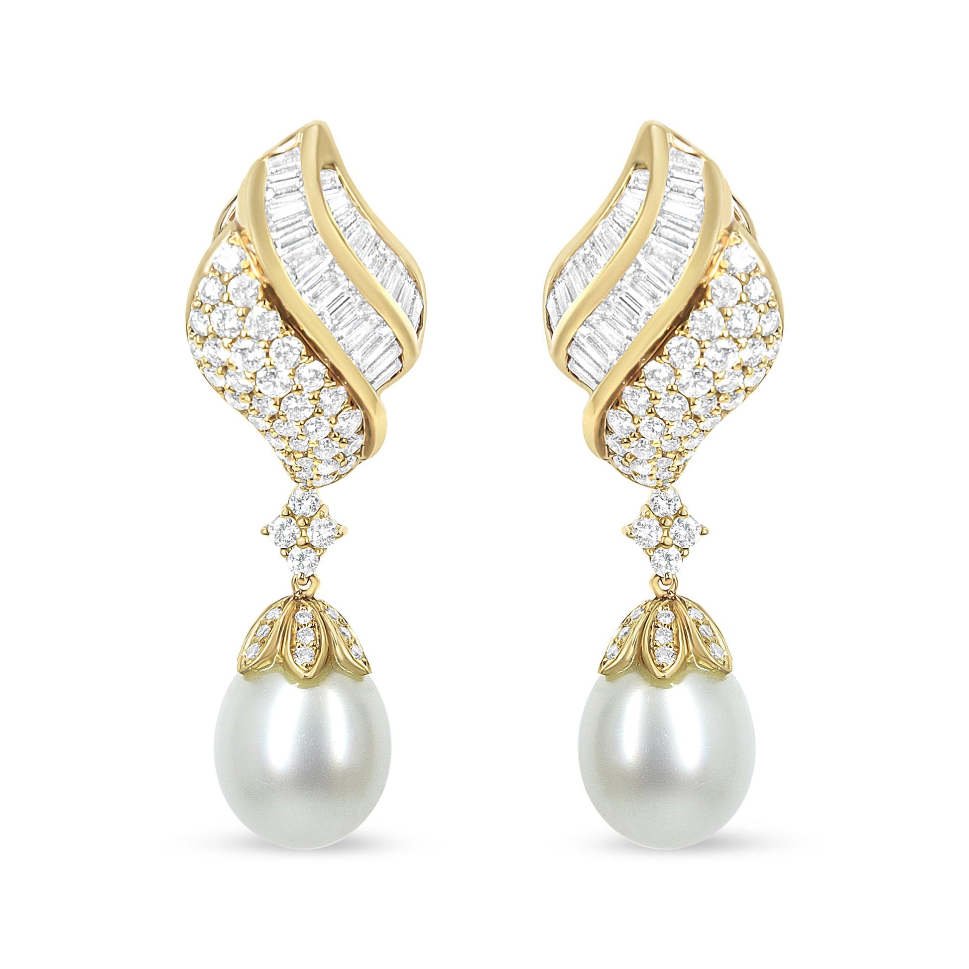 Front view of yellow metal drop earrings with curved design featuring channel-set white baguette-shaped gemstones, pavé-set round white gemstones, and large white pearl drops.