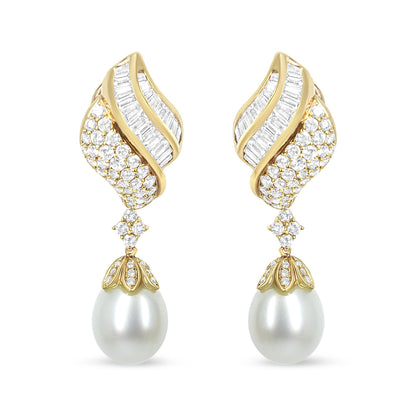 Front view of yellow metal drop earrings with curved design featuring channel-set white baguette-shaped gemstones, pavé-set round white gemstones, and large white pearl drops.