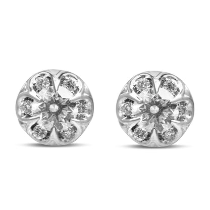 Front view of a pair of white metal round stud earrings with a larger round white gemstone in a 6-prong setting surrounded by smaller round white gemstones in 4-prong settings.