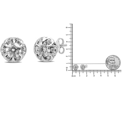Pair of white metal round stud earrings with central round white gemstone in 6-prong settings surrounded by smaller round white gemstones in 4-prong settings, shown from front and side angles, placed next to a ruler and coin for size reference.