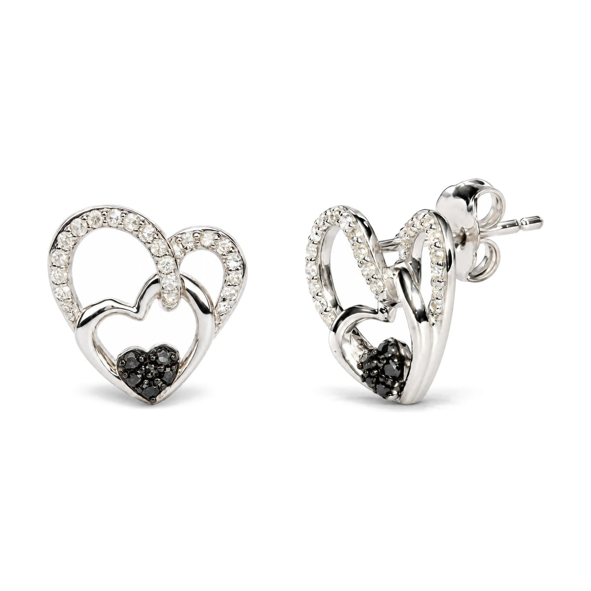 Close-up image of white metal heart-shaped earrings adorned with round white gemstones along the upper curves and small black gemstones clustered at the bottom center, shown from a front and side angle on a white background.