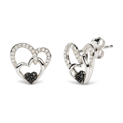 Close-up image of white metal heart-shaped earrings adorned with round white gemstones along the upper curves and small black gemstones clustered at the bottom center, shown from a front and side angle on a white background.