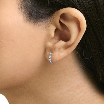 Close-up side view of a model wearing a white metal small hoop earring featuring multiple round white gemstones in a 4-prong setting.