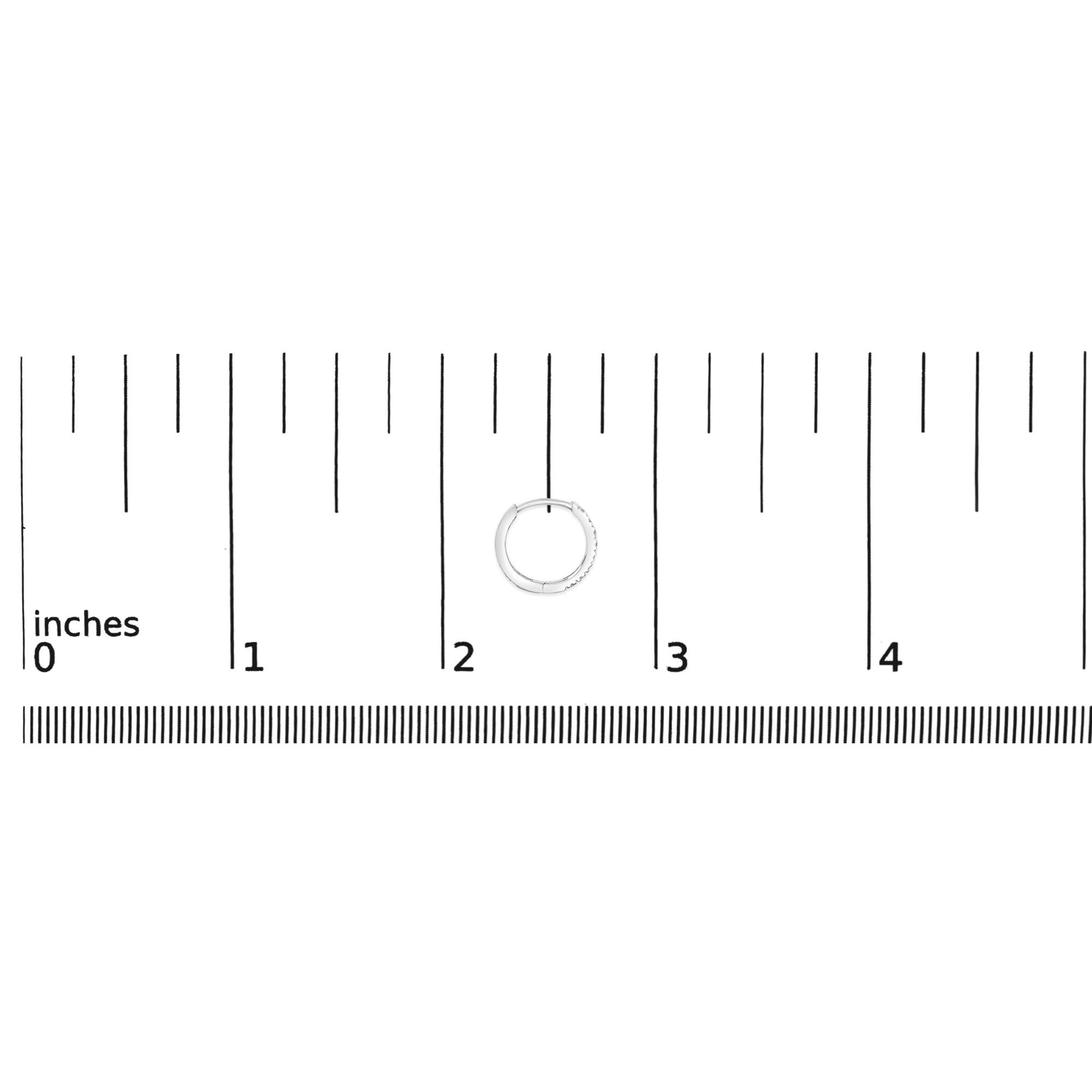 Close-up of a white hoop earring with small round white gemstones in 4-prong settings, shown on a ruler scale from a top-down angle.
