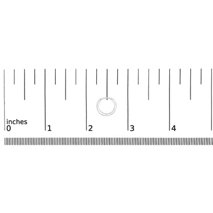 Close-up of a white hoop earring with small round white gemstones in 4-prong settings, shown on a ruler scale from a top-down angle.