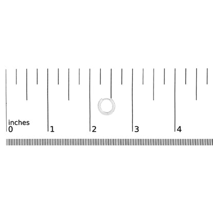 White metal hoop earring with round white gemstones in shared prong setting, shown on a ruler scale, front angle.